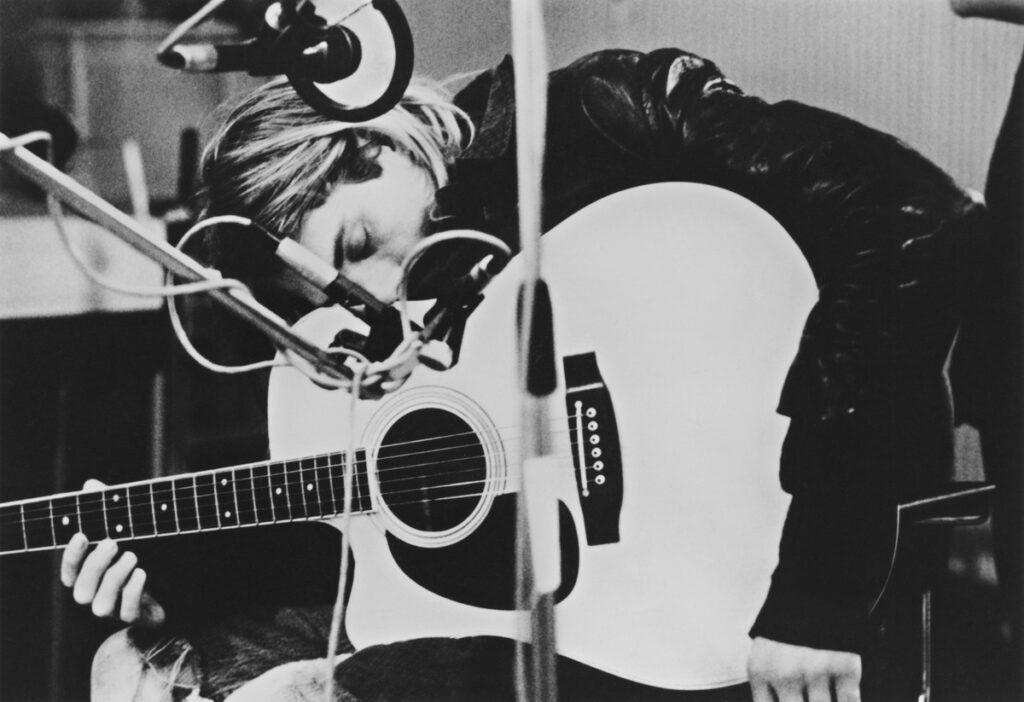 Kurt Cobain, of guitarist and singer-songwriter of Nirvana, playing a Takamine acoustic guitar during a recording session