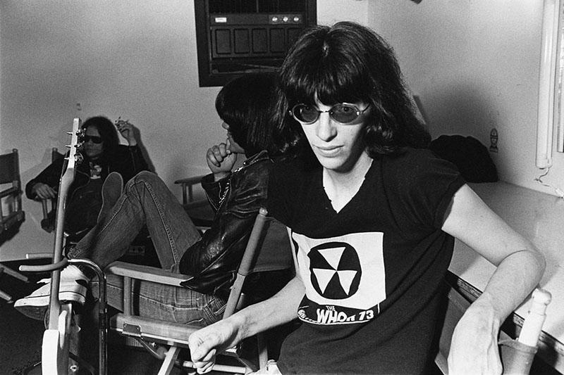 The Ramones sit on a couch calmly waiting to perform.