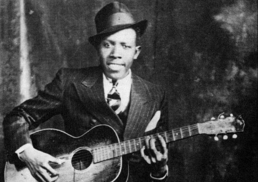 Black and white photo of Robert Johnson, renowned blues guitarist.