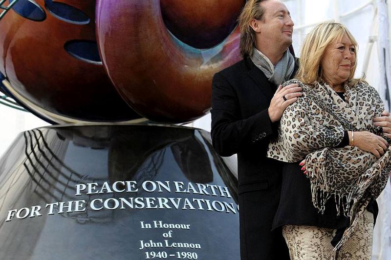 Julian puts his arms around his mother Cynthia as they pose before the john lennon monument in liverpool.
