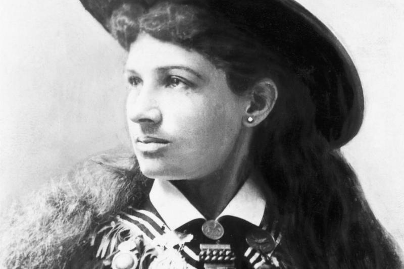 Annie Oakley wears a medal-covered vest.