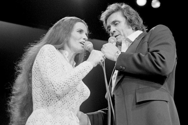 Johnny and June face towards each other while they duet onstage.