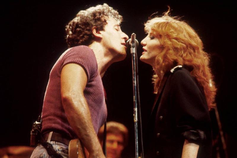 Bruce and Patti face one another while performing.