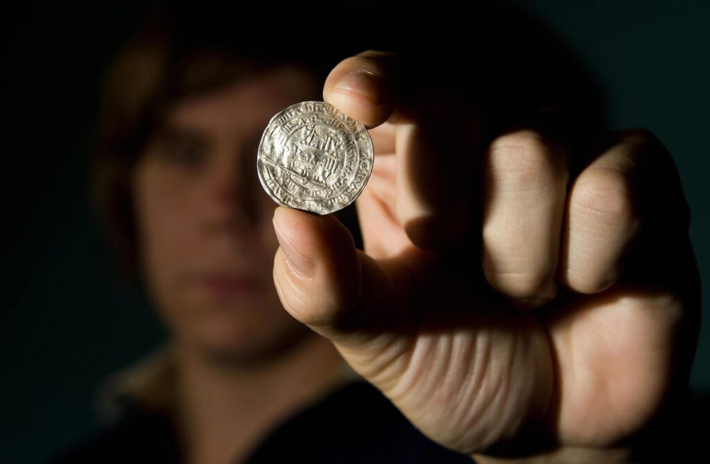 A siilver coin from the Vale of York viking hoard is displayed at a press conference to unveil the newly conserved hoard at the British Museum.