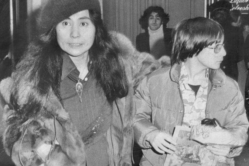 Yoko Ono wears a tense face while walking next to an oblivious teenage Julian.