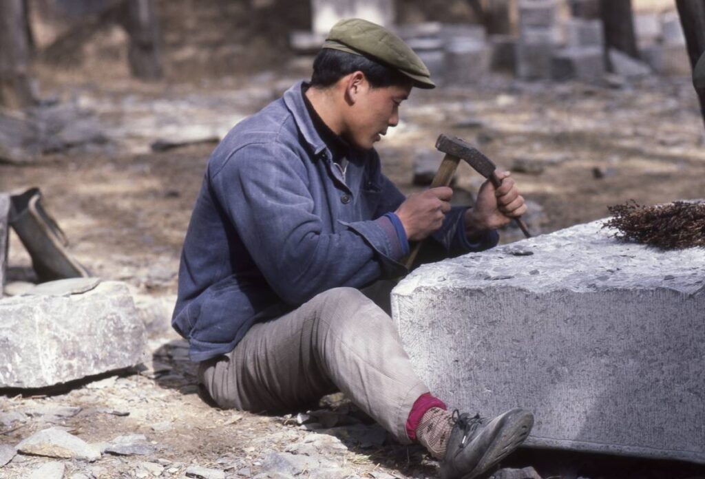 A Chinese man carves into stone, 1984.