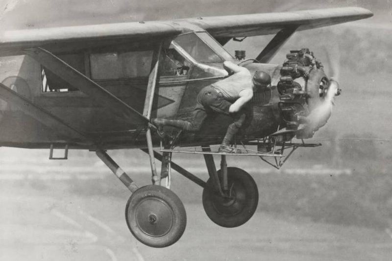 hunter brother standing on wing of plane