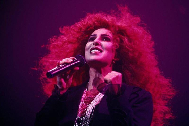 Cher performs in Paris with big, red hair.