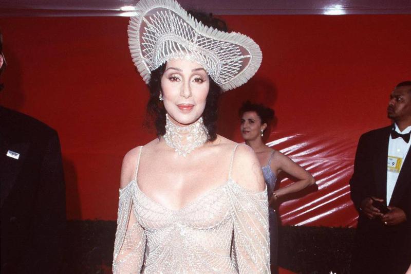 Cher wears a light gown and matching hat to an event.