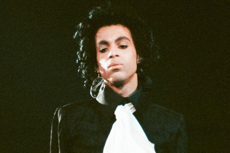 Prince looks down while performing on stage.